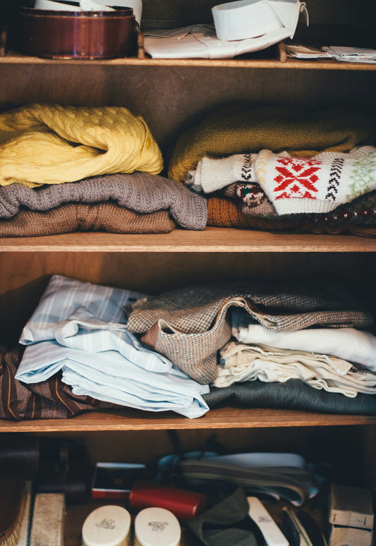 Neatly folded clothes stacked on wooden closet shelves