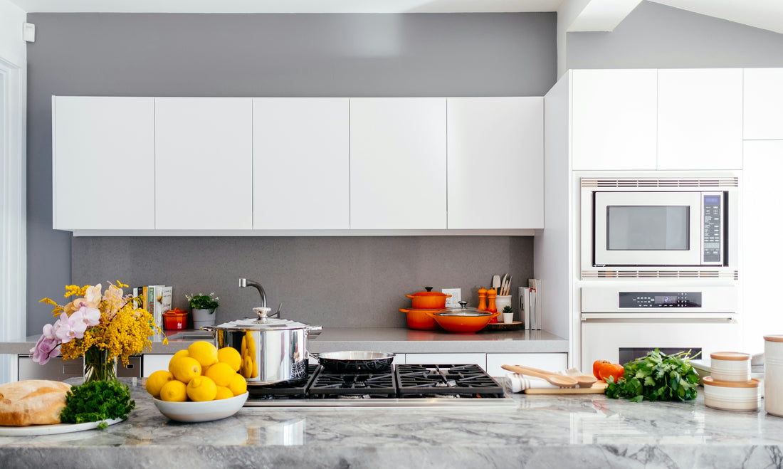 A clean, modern white kitchen with marble countertop