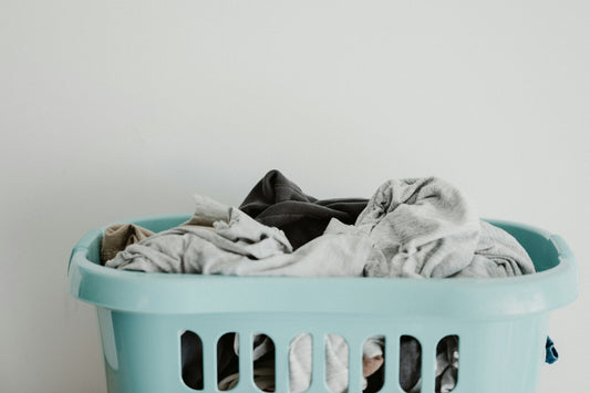 Realistic editorial lifestyle scene showing rolling laundry cart vs hamper in active household use, practical uncluttere