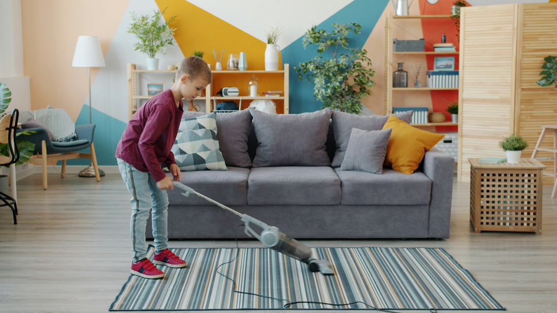 A child vacuuming a striped rug in a living room
